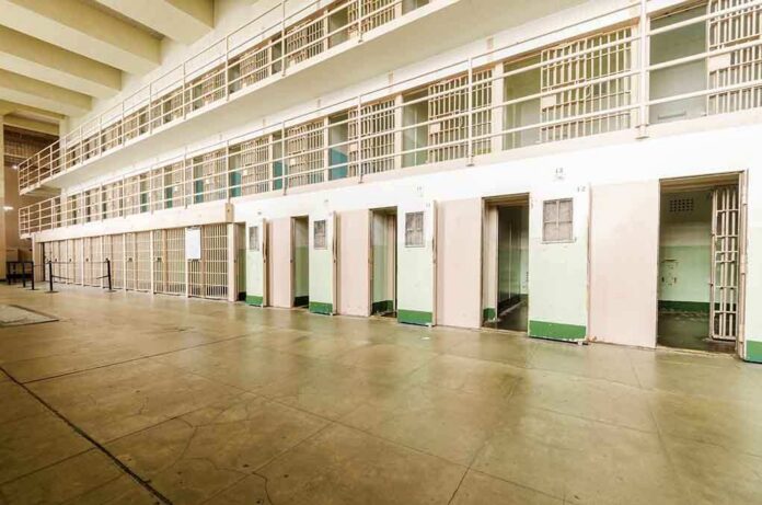 Interior view of a prison cell block with empty cells and security bars