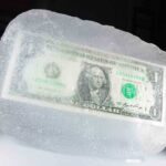 A one dollar bill encased in a block of ice