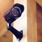 Amazon CAVES—Surveillance Nightmare Canceled A security camera mounted on a wooden wall