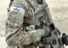 Soldier in camouflage gear with Israeli flag patch.