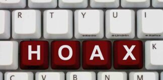 Close-up of a computer keyboard with the word HOAX spelled out in red keys