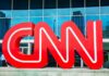 Large red CNN logo in front of a glass building