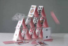A house of cards collapsing with some cards in motion