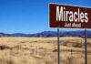 Last-Second “STOP!” — Miracle SURVIVOR A road sign reading 'Miracles Just ahead' in a desert landscape