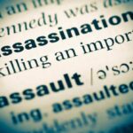 Close-up of a dictionary page showing the definition of 'assassination'
