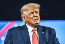 Man in suit speaking at a podium.