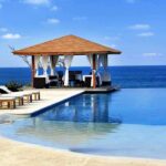 LGBTQ Migrants Get Spa Days—City BROKE A luxurious poolside gazebo overlooking the ocean with sun loungers