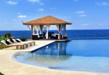 A luxurious poolside gazebo overlooking the ocean with sun loungers