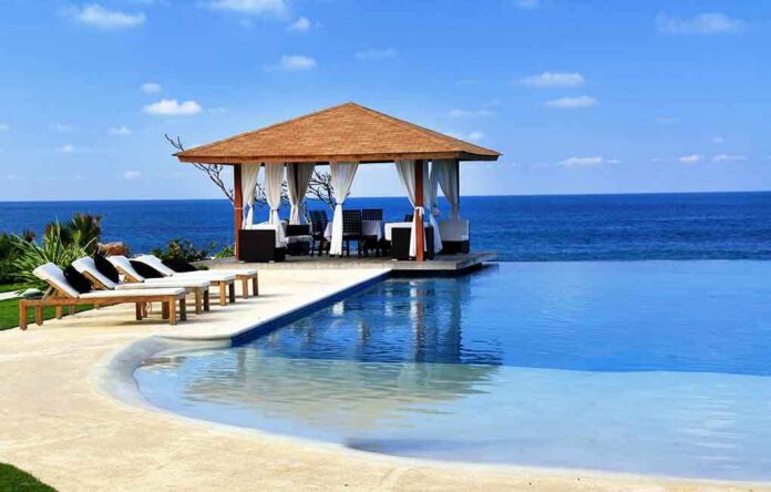 A luxurious poolside gazebo overlooking the ocean with sun loungers