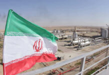 Iranian flag near an industrial gas refinery.