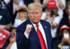 Michelle Obama’s Jaw-Dropping Trump Voter Analysis Man in suit making a fist gesture at rally.