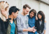 Group of friends looking at a smartphone.