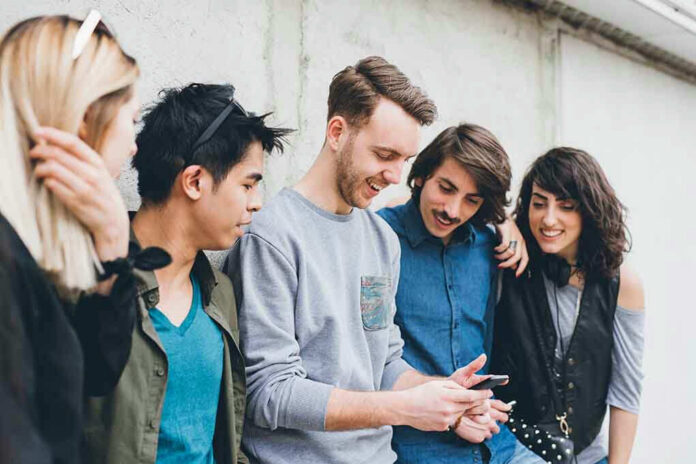 1908675214 Group of friends looking at a smartphone.