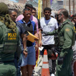 Hispanic Voters Defy Mass Deportation Myth Border patrol agents inspecting group of individuals in line.
