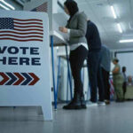 Trump Topples Rebel Congressman – He’s OUT! Sign reading Vote Here in a polling station.