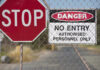 Airport HORROR: Trespasser Meets Tragic End Stop and Danger signs on a chain-link fence.