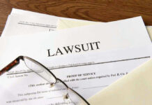 Documents labeled Lawsuit with glasses on top.