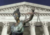 Lady Justice statue in front of courthouse.