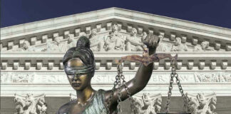 Lady Justice statue in front of courthouse.