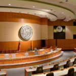 Redefining Personhood: Unborn Children’s Rights at Risk Interior view of a government chamber with wooden paneling and seating