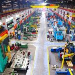 AI Threat: HALF of Office Jobs Vanishing? Aerial view of a large industrial workshop filled with various machinery and equipment