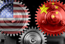 Pentagon Drops $500M Bomb On China Grip Interlocking gears with USA and China flags.