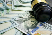 Health Care Heist Exposed Gavel and hundred dollar bills on table.