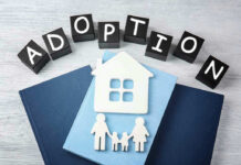 Adoption blocks, books, house, and family paper cutouts.