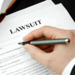 He Stole From Hungry Kids… Then Vanished Hand holding pen, filling out lawsuit form.