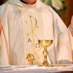 Why Catholic Men Were Told Not To Pray At Cathedral A priest holding a golden chalice during a religious ceremony