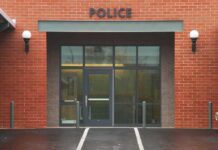 Outrage Erupts: Teacher, Guns, Deadly Night Entrance of a modern police station with brick facade