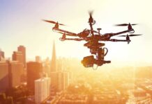 A drone flying over a city skyline during sunset