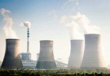 China Overtakes U.S. Nuclear Crown Four cooling towers of a power plant emitting steam.