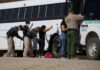 Immigration Enforcement Just Got Turned Into ‘Mega-Project’ Border patrol officers investigating people near a bus.