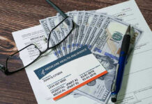 Medicaid Fraud Factories Exposed Medicare card glasses pen money on wooden table