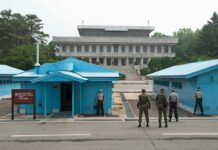 Israel’s Wild Ask—Washington Went Quiet Military personnel standing near blue buildings at a border crossing