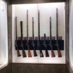 Display case with a row of antique muskets