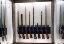Display case with a row of antique muskets