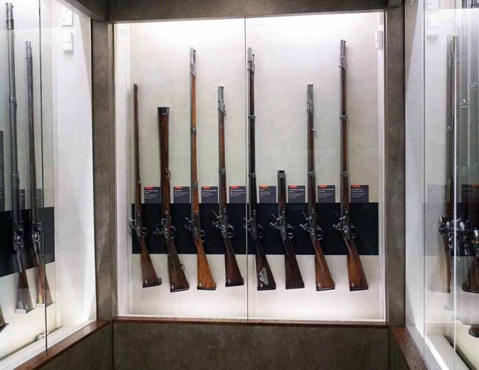 Display case with a row of antique muskets