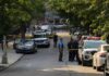 Mount Eden Chaos: Kid Caught In Crossfire Police officers secure a residential street with patrol cars and yellow tape