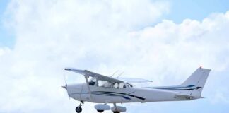 Single-engine airplane flying against a cloudy sky