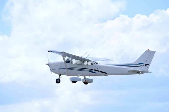 Single-engine airplane flying against a cloudy sky
