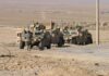 U.S. Launches Large-Scale Military Relief Mission Two military humvees with soldiers in a desert landscape