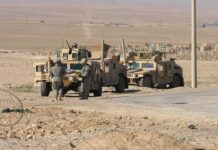 U.S. Launches Large-Scale Military Relief Mission Two military humvees with soldiers in a desert landscape