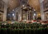 Pro-LGBT Cardinal Praised as Traditional Latin Mass Faces New Crackdown Clergy in green vestments gather under a grand baroque canopy in a vast cathedral