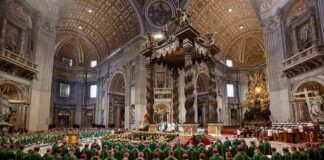 Clergy in green vestments gather under a grand baroque canopy in a vast cathedral