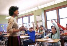Teacher BUSTED After 5 Fake ‘Active Shooter’ Alerts Teacher engaging with students raising hands in a classroom