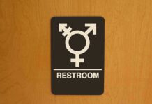 Dem Says ‘NO MEN’ in Women’s Locker Rooms… Then THIS Surfaces Restroom sign with gender-inclusive symbol on wooden door