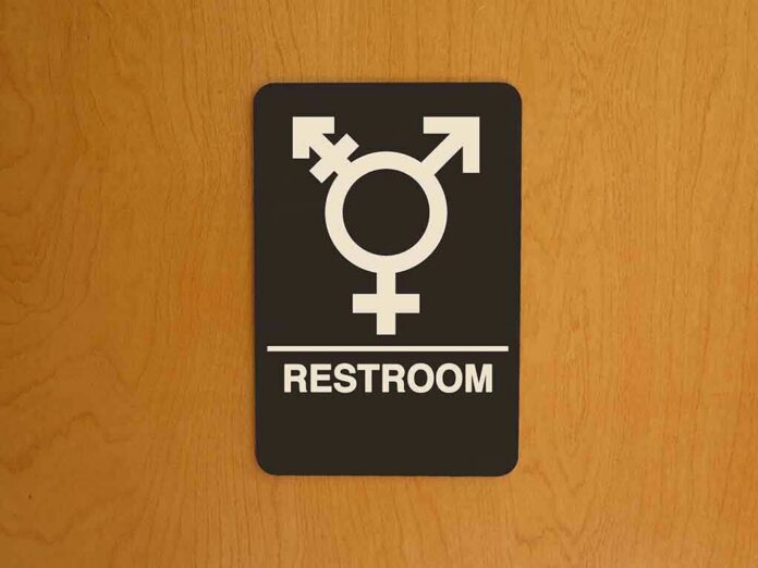 Restroom sign with gender-inclusive symbol on wooden door