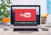 Trump’s H-1B Plan Comes With a $100K SHOCK YouTube logo on a laptop screen on desk.